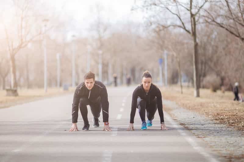 Young sport couple in starting position preparing for run